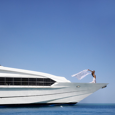 woman enjoying by standing on the yacht and letting her hair loose